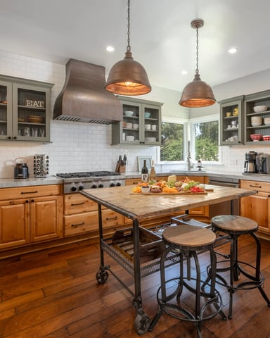 Spacious kitchen with wood cabinets, white subway tile backsplash, gas range, island with bar seating, and copper pendant lights